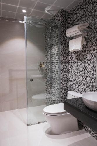a bathroom with a toilet and a glass shower at Navy Hotel Hà Nội in Hanoi