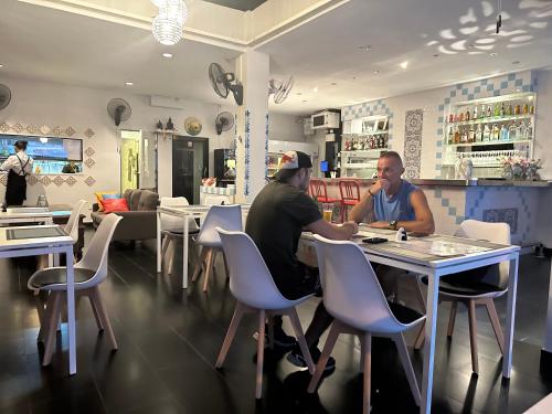 Due uomini seduti a un tavolo in un ristorante di Lotus Art Guesthouse a Pattaya Sud