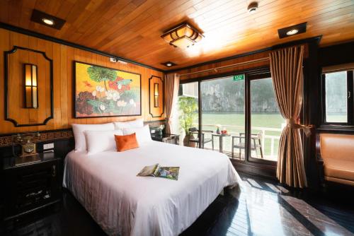 Arcady Boutique Cruise في ها لونغ: غرفة نوم بسرير كبير وبلكونة