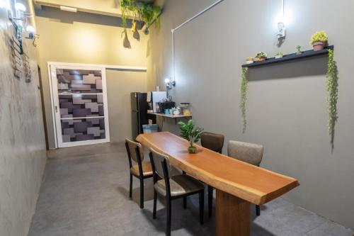 a dining room with a wooden table and chairs at Zenz Hotel in Kulai