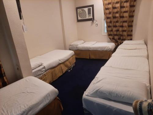 a room with three beds in a hospital room at Bestex Group of Hotels in Makkah