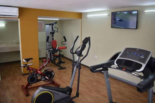 Zimmer mit einem Fitnessraum mit Fahrrädern und einem Laptop auf einem Laufband in der Unterkunft Apartamento de lujo belen medellin. Piscina y gym in Medellín