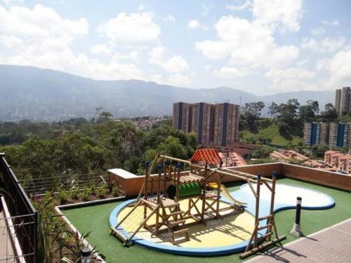 ein leerer Spielplatz auf einem Gebäude mit Bergen im Hintergrund in der Unterkunft Apartamento de lujo belen medellin. Piscina y gym in Medellín