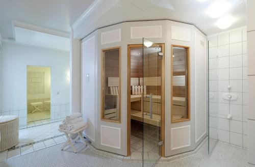 a bathroom with a walk in shower and a glass door at Romantik Hotel Gebhards in Göttingen