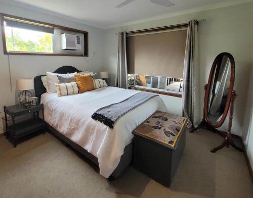 a bedroom with a large bed and a mirror at River Heads Appartment in River Heads