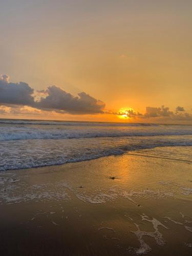 a sunset on a beach with the ocean at Tres Velas Surf in Celestino Gasca