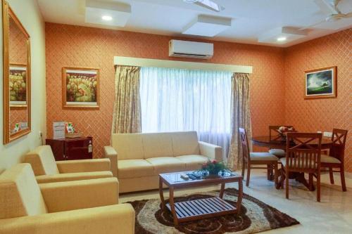 a living room with a couch and a table at HOTEL ROYAL GRANDE in Vellore