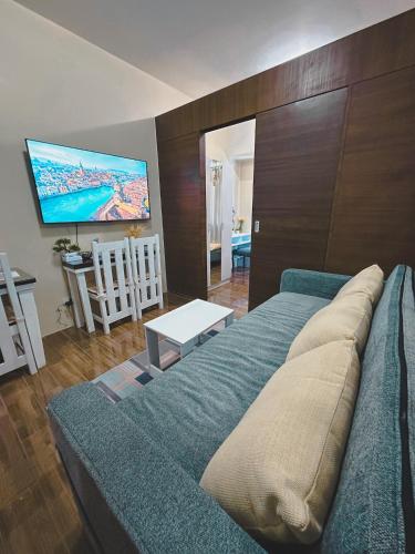 a living room with a couch and a flat screen tv at Apartment Condo in Air Residences Makati wifi Netflix Disney, pool & mall in Manila