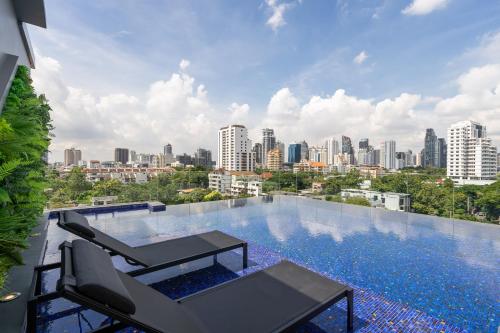 a swimming pool with a view of a city at Destiny63 Ekamai Apartment in Bangkok