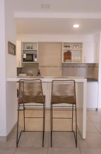 eine Küche mit 2 Stühlen auf einer Kücheninsel in der Unterkunft Casa Mate in Salta