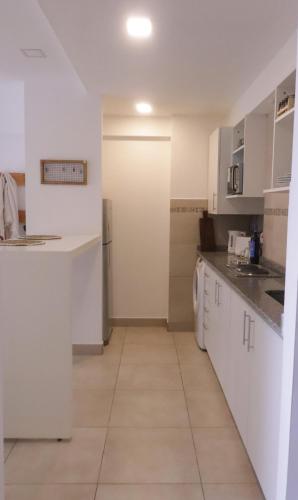 eine Küche mit weißen Schränken und weißen Geräten in der Unterkunft Casa Mate in Salta