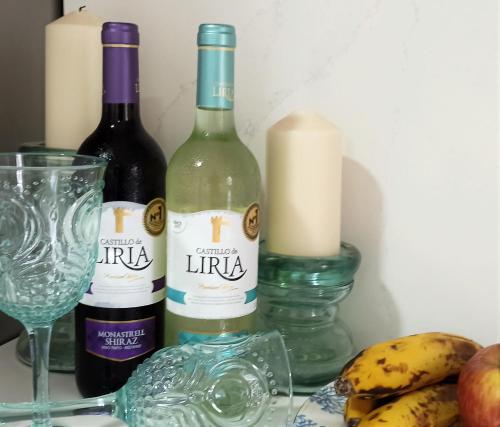 two bottles of wine and a glass and some bananas at SeawaveSunGranCanaria in Telde