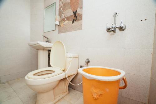 a dirty bathroom with a toilet and a bucket at Hotel A V International in New Delhi