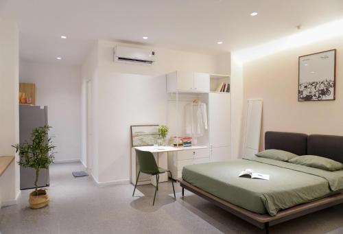a bedroom with a bed and a table and a desk at M Village Lê Văn Sỹ in Ho Chi Minh City