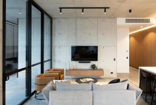 a living room with a couch and a tv at Alfred & Turner Apartments, Luxury 2 Bedroom Condos in the heart of the Valley in Brisbane