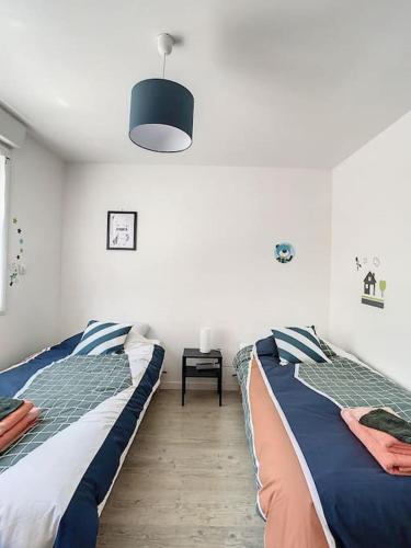 - une chambre avec 2 lits jumeaux et une lampe dans l'établissement Grande Maison Cosy Terrasse Parking Gare 8 Pers, à Amiens