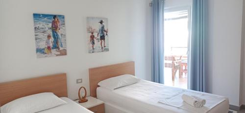 ein Hotelzimmer mit 2 Betten und einem Fenster in der Unterkunft Matthews Beach House in Vlorë