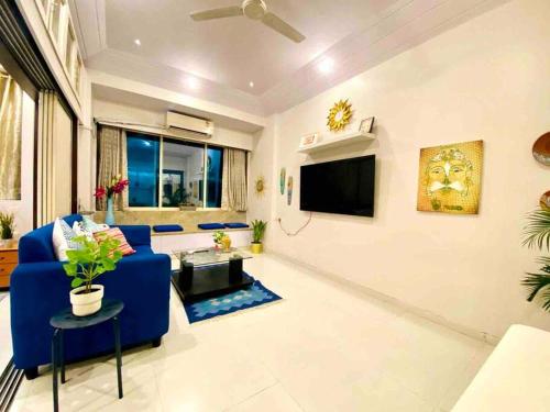 孟買的住宿－Arora Bhavan 1BHK-1B, Khar West by Connekt Homes，客厅配有蓝色的沙发和电视
