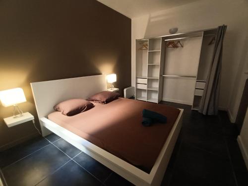 - une chambre avec un lit avec deux oreillers et un réfrigérateur dans l'établissement Spacieux T3 place Comédie gare Saint Roch, à Montpellier
