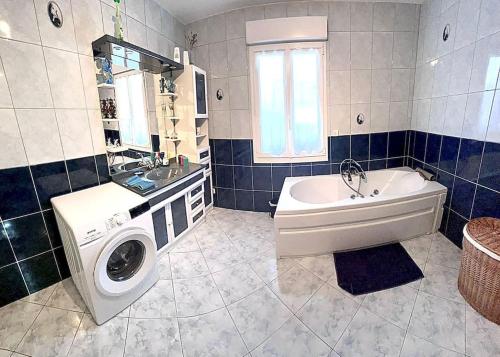 bagno con lavatrice, vasca e lavandino di La belmarienne (à 5 min de Montreuil sur Mer) a Beaumerie-Saint-Martin