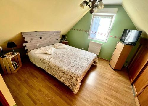 1 dormitorio con 1 cama y TV en La belmarienne (à 5 min de Montreuil sur Mer) en Beaumerie-Saint-Martin
