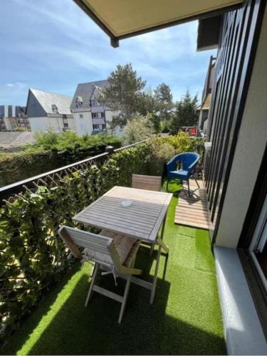 a patio with a table and chairs on a balcony at Appartement résidence proche mer et Thalassothérapie in Cabourg