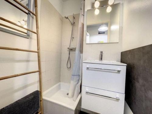 a small bathroom with a sink and a tub at Appartement résidence proche mer et Thalassothérapie in Cabourg