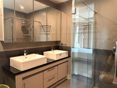 a bathroom with two sinks and a glass shower at Palm Oasis Pool Villa by Pattaya Holiday in Jomtien Beach