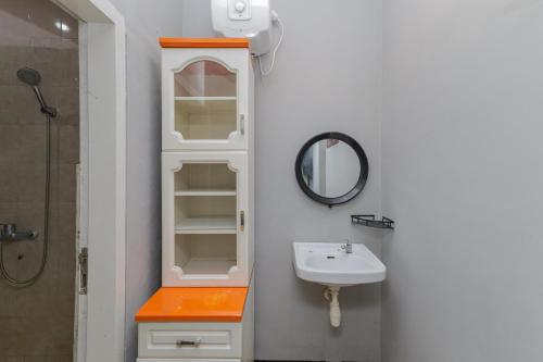 a white bathroom with a sink and a mirror at RedDoorz Plus At Swun Stay Raya Langsep in Malang
