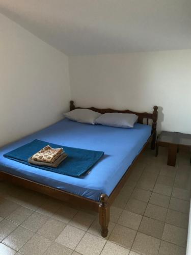 a bedroom with a bed with a blue mattress and a table at Apartman Novica in Herceg-Novi