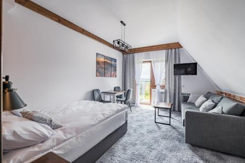 1 dormitorio con 1 cama y 1 sofá en Willa Rzoz en Bukowina Tatrzańska