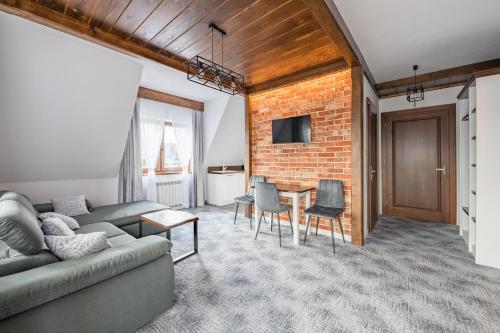 a living room with a couch and a brick wall at Willa Rzoz in Bukowina Tatrzańska