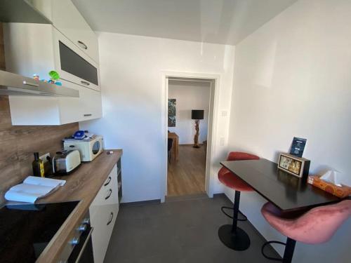 eine Küche mit einem Schreibtisch und einem Tisch in einem Zimmer in der Unterkunft Wunderbare Ferienwohnung mit Nähe zum Badesee in Goldenstedt