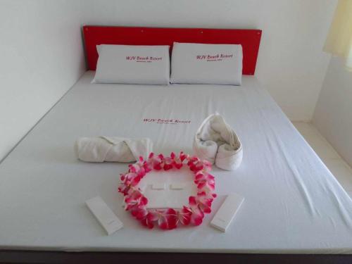 a bed with two shoes and a cake on it at WJV BEACH RESORT MOALBOAL in Cebu City