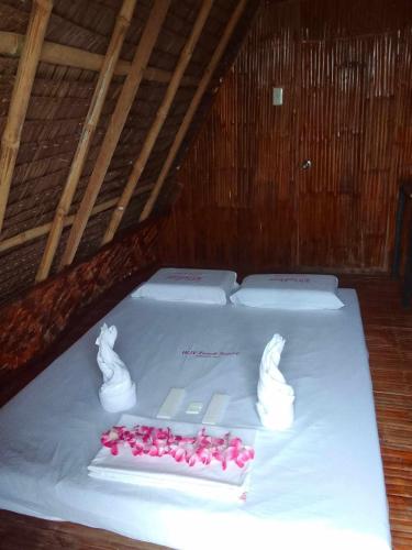 a white cake with pink roses on a table at WJV BEACH RESORT MOALBOAL in Cebu City