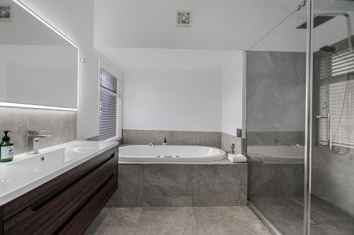 a bathroom with a tub and a sink and a bath tub at Tasman Holiday Parks - Papamoa Beach in Papamoa