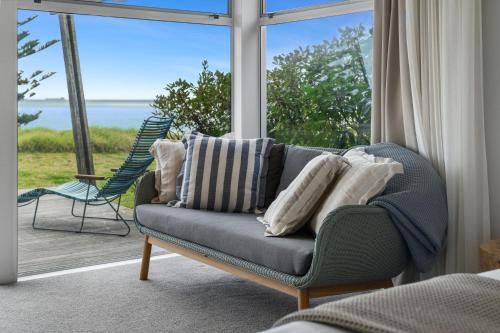 a living room with a couch in front of a window at Tasman Holiday Parks - Papamoa Beach in Papamoa