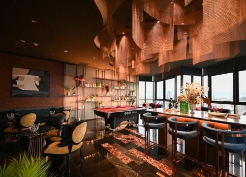 een bar met krukken in een kamer met ramen bij Condo Edge Central in Pattaya