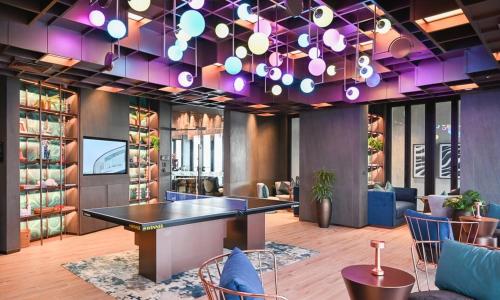 芭達雅中心的住宿－Condo Edge Central，一间设有桌子和紫色照明的用餐室