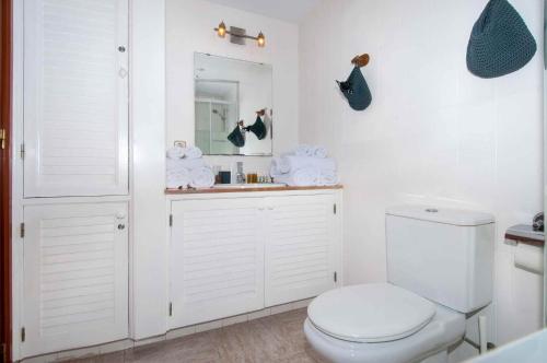 マスパロマスにあるMaspalomas Suitesの白いバスルーム(トイレ、鏡付)