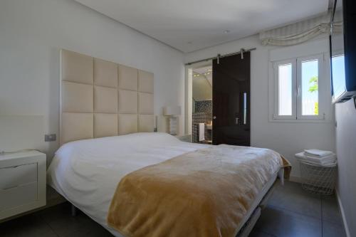 a bedroom with a large bed and a window at FaroVela Suites Pasito Blanco in Pasito Blanco