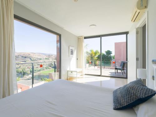 a bedroom with a large bed and a large window at Salobre Villas in Salobre