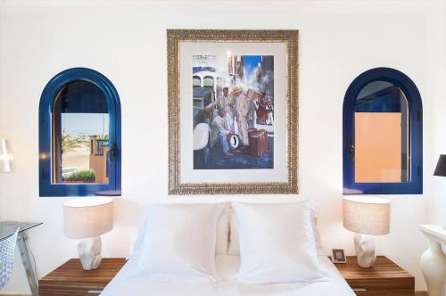 a bedroom with two windows and a bed with two pillows at Meloneras Suites in Meloneras