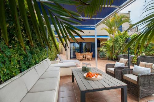 a patio with a couch and a table and chairs at Meloneras Suites in Meloneras