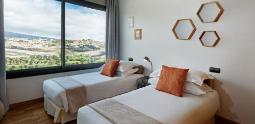 サロブレにあるSalobre Villas Deluxe XLの大きな窓付きの客室で、ベッド2台が備わります。