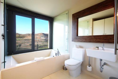 a bathroom with a tub and a toilet and a sink at Salobre Villas Deluxe in Salobre