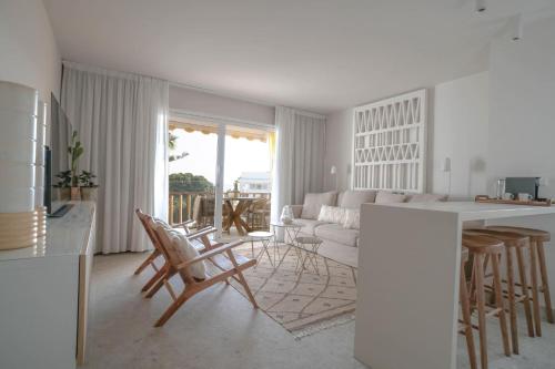 a white kitchen and living room with a table and chairs at Agustino Beach Suites San Agustin in San Agustin