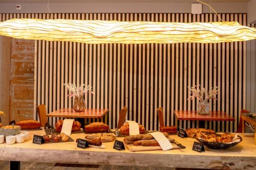 a table topped with lots of different types of food at Hotel du Golf in Corrençon-en-Vercors