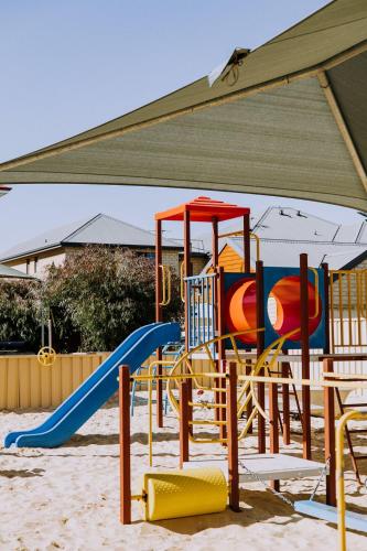 a playground with a slide in the sand at The Jetty Resort in Esperance
