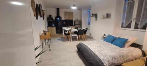 a bedroom with a bed and a kitchen with a table at La Campagne à la ville dans pavillon avec jardin Clos et privatif in Héricourt